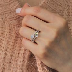 a woman's hand wearing a diamond ring