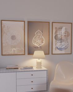 three framed pictures hang on the wall next to a white dresser with a lamp in front of it