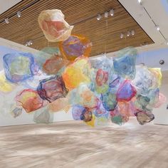 an art installation in a large room with lots of colorful objects hanging from the ceiling