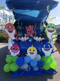 an inflatable boat with shark decorations on it's sides and balloons attached to the front