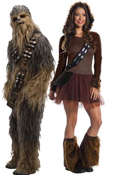 a woman standing next to a man dressed as chew - oo and star wars character