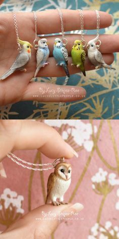 small birds are perched on the fingers of someone's hand and they appear to be wearing tiny necklaces