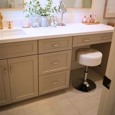 a bathroom with two sinks and a stool in front of the vanity area is shown