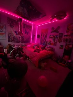 a bedroom with pink lights and pictures on the walls