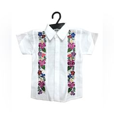 Your Boy Will Look Amazing Wearing One Of Our Fine Boy’s Guayabera Made With White Linen Fabric And Embroidered With Silk Thread, Features Hidden Buttons For A More Elegant Look. The Multicolor Floral Pattern Is Perfect To Wear At Any Mexican Or Fiesta Themed Event Like Weddings, Xv’s, Mexican Party, Etc. *Color Of Flower Embroidery May Change In Every Shirt* Embroidery For Boys, Fine Boy, White Linen Fabric, Poncho Shawl, Boys Jewelry, Mexican Party, Flower Boys, Linen Short, Fine Linen