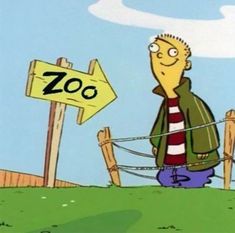 a man standing in front of a zoo sign with the word zoo written on it