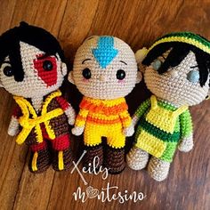 three small crocheted dolls sitting next to each other