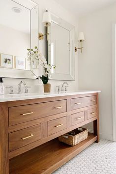 a bathroom with double sinks and large mirrors