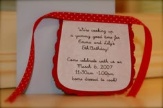 a red and white birthday card with a polka dot ribbon tied around the back of it