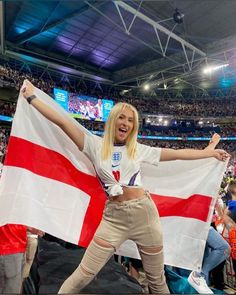 a woman holding an england flag at a sporting event