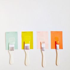 four paint brushes lined up in different colors