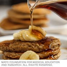 pancakes with syrup being poured onto them and bananas on the top, along with text describing mayo foundation for medical education and research all rights reserved