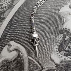 A dagger and skull necklace in sterling silver. Inspired by tattoo design and symbolism - death, protection and bravery.Chain length = 18", 20", 22"and 24"Skull pendant height = 27mmSterling SilverHandmade in NYC Fantasy Clothing Art, Dagger Necklace, Inspired Clothes, Halloween Vampire, The Bayou, Clothing Art, Gothic Horror, Skull Jewelry, Skull Necklace