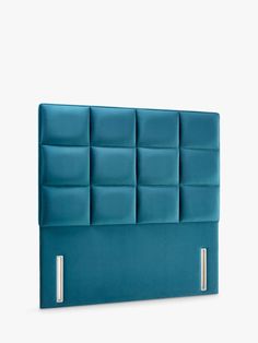 an upholstered headboard made from blue fabric with metal posts and square shapes