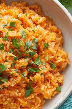 a white bowl filled with rice and garnished with parsley