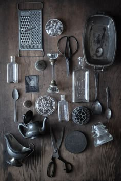 an assortment of kitchen utensils and spoons on top of a wooden table