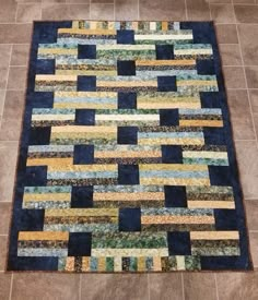 a blue and yellow area rug on the floor in a room with tile floors,