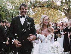 a bride and groom are walking through confetti thrown in the air at their wedding