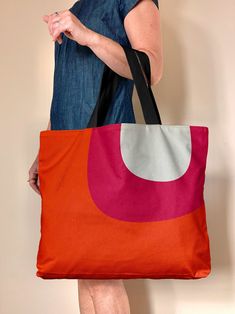 "My colorful, mod tote bag is a large orange and pink carryall. This mid century style tote is oversized with lined cotton canvas. Great for your roller-skates, beach, groceries, and overnights. Check out the handy wallet sized pockets on the inside, the bag is fully lined with a snap closure. Extra room to fit all the things. This colorful bag is a great girlfriend gift, mostly I'm seeing folks nab them for theirselves (encouraged!) Made to order. The original artwork is designed here in my stu Cheap Orange Tote Canvas Bag, Affordable Cotton Retro Bags, Cheap Orange Canvas Shoulder Bag, Cheap Retro Tote Hobo Bag, Cheap Retro Cotton Bags, Affordable Retro Summer Canvas Bag, Cheap Orange Bags For Summer, Cheap Retro Box Bag For Shopping, Cheap Orange Shoulder Beach Bag