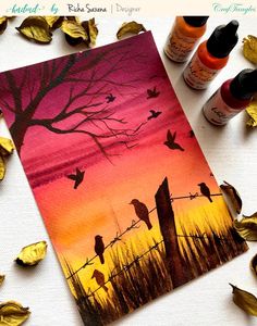 an image of birds on a wire at sunset with leaves scattered around it and paint bottles next to it