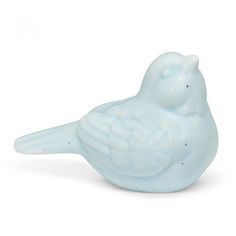 a white bird figurine sitting on top of a table