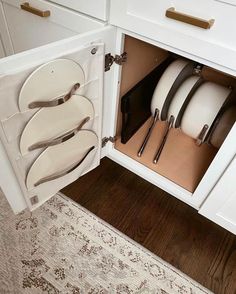 an open cabinet with plates and silverware in it