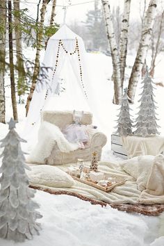 a white couch sitting on top of a snow covered ground next to christmas tree decorations