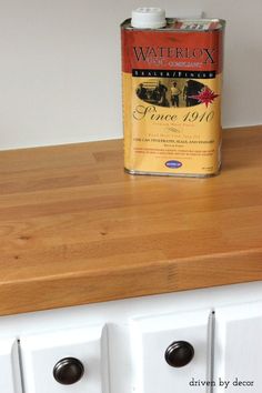 a can of wine sitting on top of a wooden counter next to two white drawers