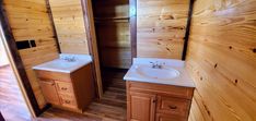 a bathroom with two sinks and wooden walls