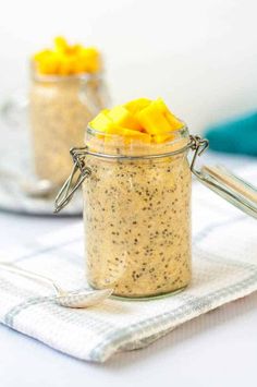 two small jars filled with oatmeal and fruit on top of a table