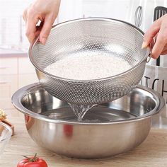 a person is grating rice in a strainer on a counter top next to tomatoes