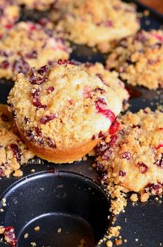 muffins with crumbled toppings sitting on top of a pan