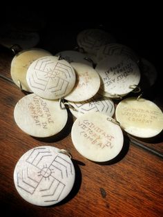 several white buttons with writing on them sitting on a wooden table next to each other