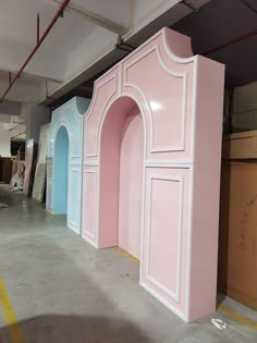 three large pink and blue booths in a warehouse