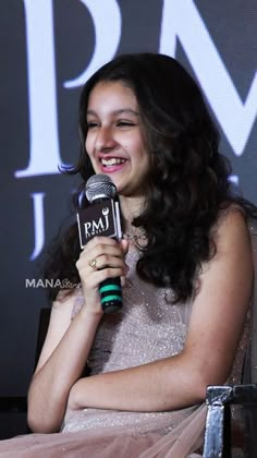 a woman sitting in a chair holding a microphone