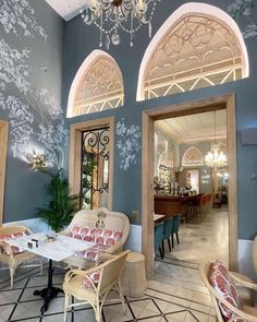 the inside of a restaurant with blue walls and chandelier hanging from the ceiling