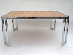 a table made out of metal and wood with a square shaped wooden top on the bottom