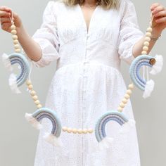 a woman wearing a white dress holding beads