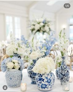 blue and white vases with flowers in them on a table at a wedding reception