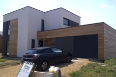 a car is parked in front of a house with two garages on each side