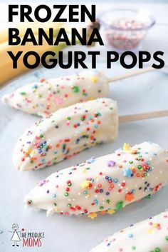 frozen banana yogurt pops with sprinkles are on a white plate