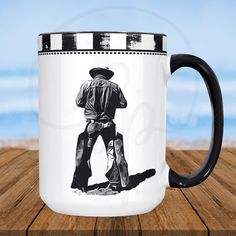 a black and white coffee mug with a drawing of a man in cowboy gear on it