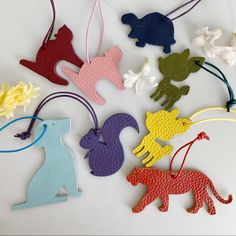 several different colored wooden animal ornaments on a white surface