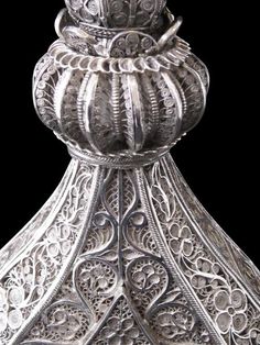 an ornate silver vase is shown against a black background