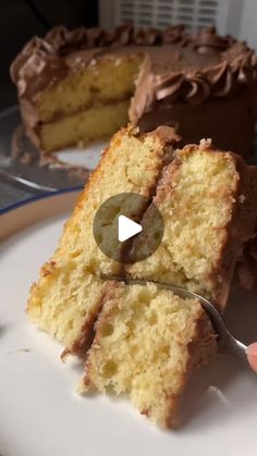 a piece of cake with chocolate frosting being cut by a knife on a plate