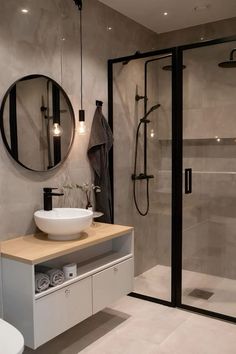 a bathroom with a sink, mirror and shower stall in it's center area