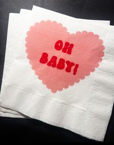 two napkins with the words oh baby printed on them are sitting next to each other