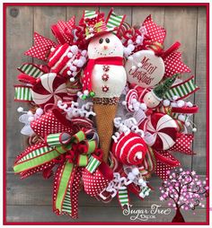 a christmas wreath with a snowman and candy canes in the shape of an ice cream cone