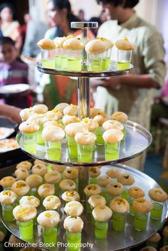 a three tiered tray filled with cupcakes and pastries