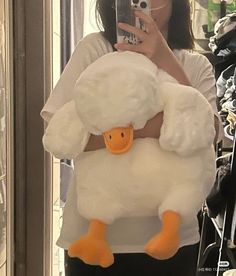 a woman taking a selfie while holding a stuffed duck